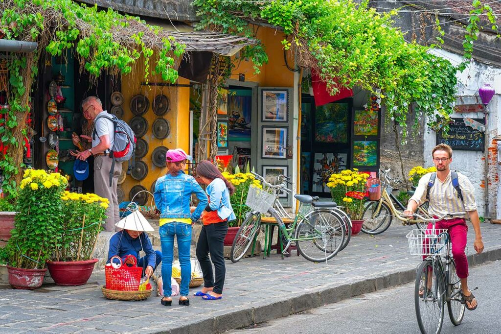 Straat in Hoi An Ancient Town in de winter met gele huizen, fietsen en bloemen voor traditionele winkels