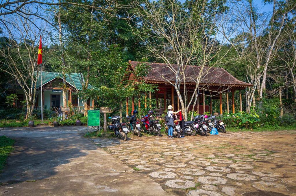Ingang en parkeerplaats van de Phong Nha Botanic Garden, met motorbikes en bezoekerscentrum bij de start van de wandelroutes