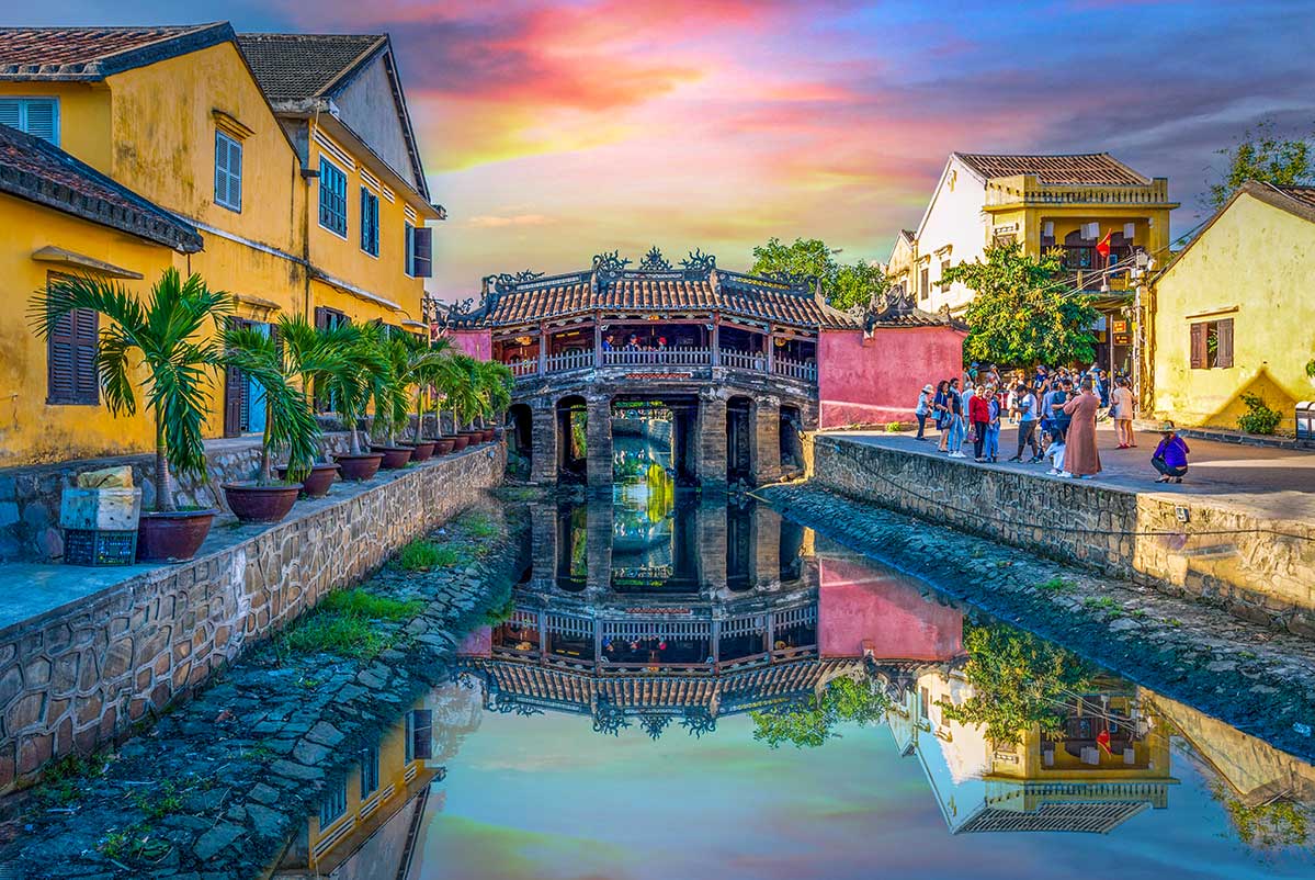 Japanse Brug in Hoi An met weerspiegeling in het water van het kanaal bij zonsondergang