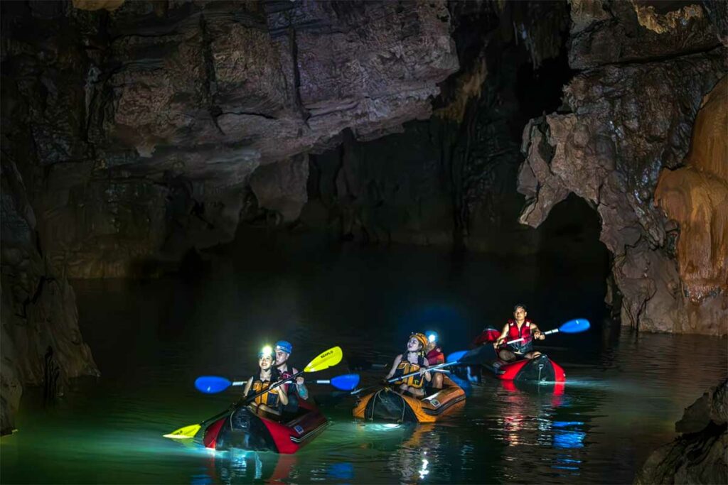 Kajakken in Phong Nha Cave tijdens een avontuurlijke grottocht over de ondergrondse rivier, dieper in de grot dan de standaard bootroute.
