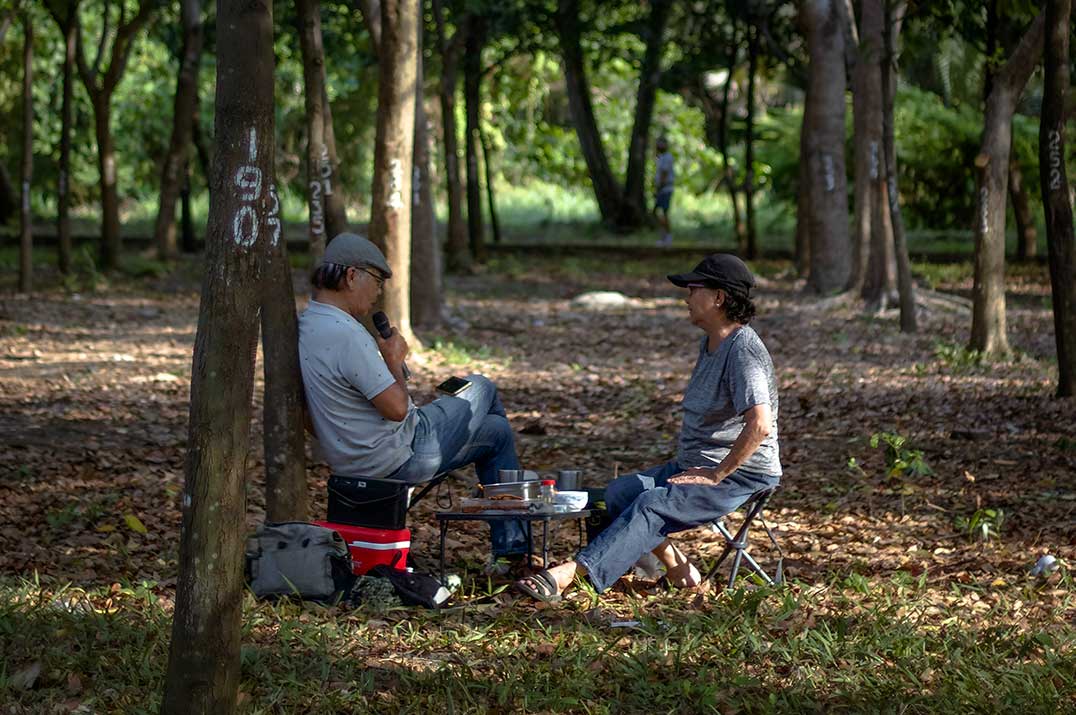 Twee locals zingen rustige karaoke buiten in een park in Vietnam, ontspannen en kleinschalige vorm van karaoke