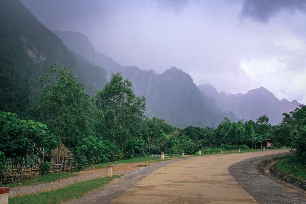 Rustige weg door het bergachtige landschap langs de Ho Chi Minh Trail, omgeven door jungle en kalkstenen heuvels.