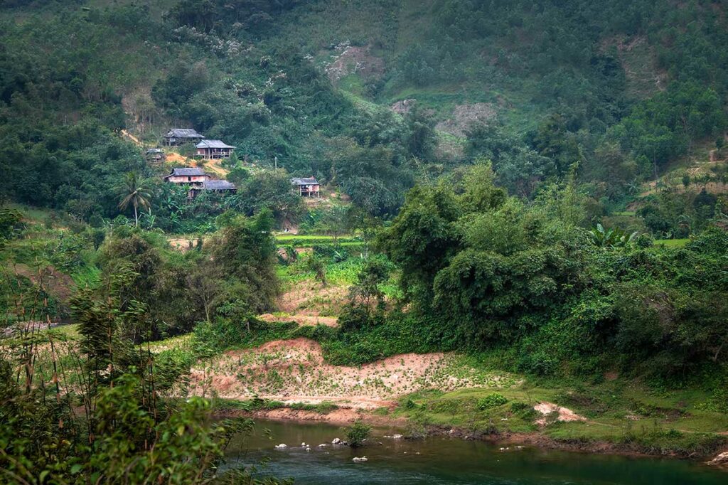 Landelijk gebied langs de Ho Chi Minh Trail in Quang Tri, met rivier, kleine dorpen en beboste heuvels.