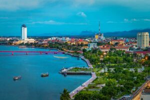 Avondluchtfoto van Dong Hoi met de Nhat Le-rivier, stadsverlichting en de boulevard langs het water in centraal Vietnam.