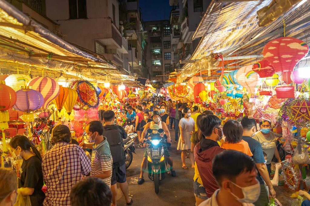 Drukke lantaarnstraat in Chinatown in Ho Chi Minh City tijdens het Mid-Autumn Festival, met kraampjes vol kleurrijke lampionnen en veel lokale bezoekers in de avond.