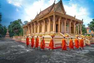 Boeddhistische monniken in oranje gewaden lopen langs Khleang Pagoda in Soc Trang