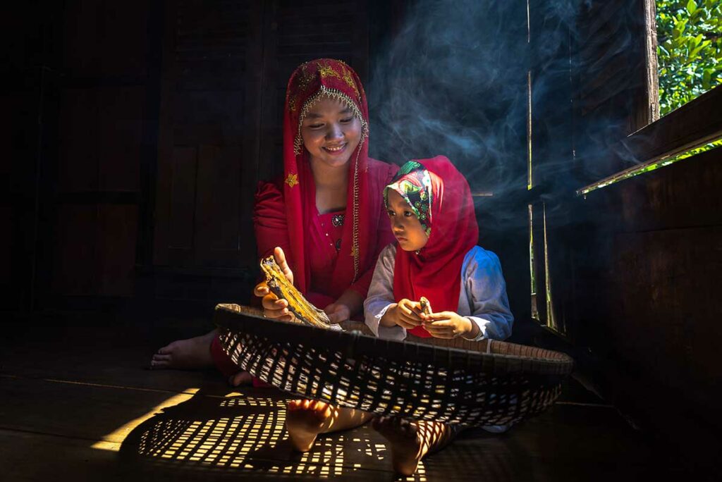 Cham moslim vrouw en kind in traditioneel dorp bij Chau Doc Mekong Delta in houten huis met natuurlijk licht
