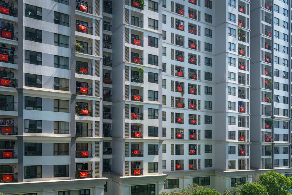 Appartementencomplex in Vietnam waar bijna elk balkon is versierd met de Vietnamese vlag tijdens een nationale feestdag.