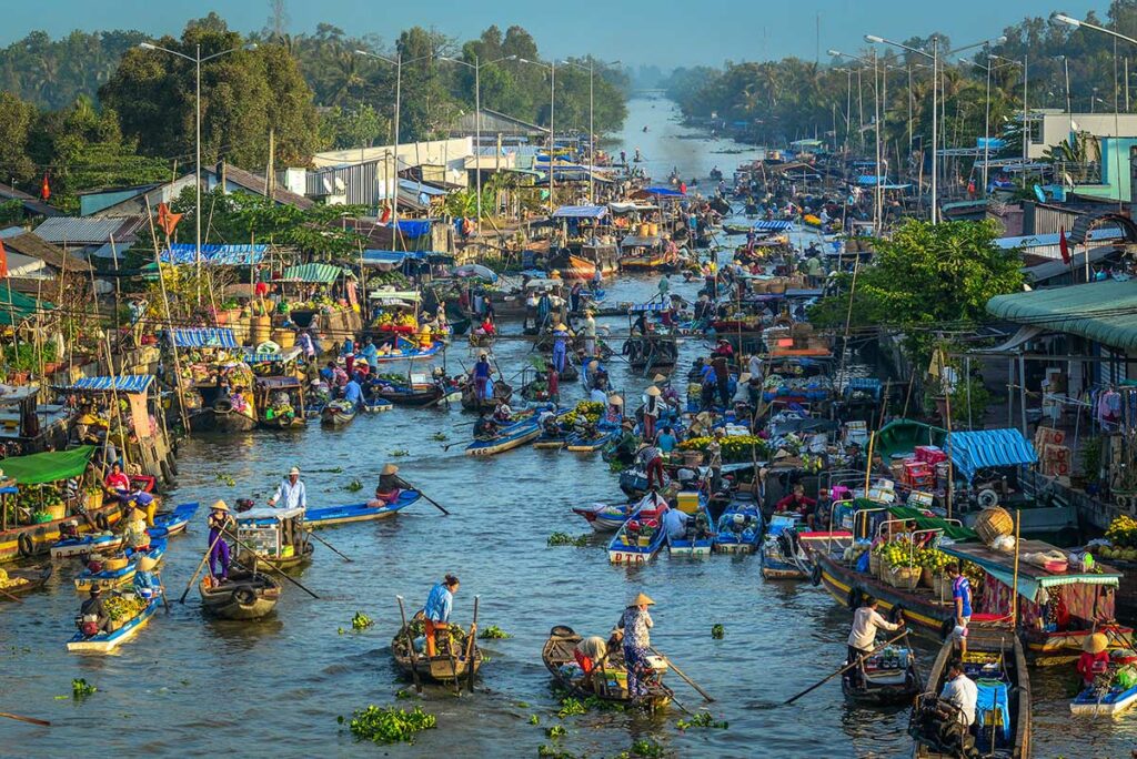 Historische Nga Nam drijvende markt in Soc Trang met tientallen boten vol fruit en handel op smalle rivier