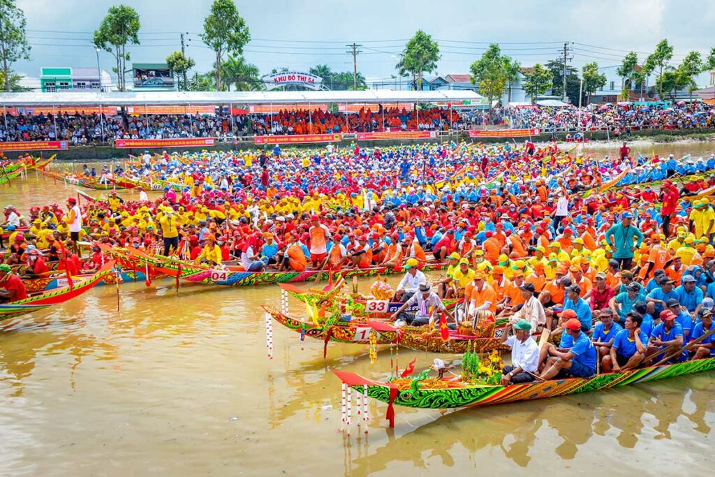 Drukke Ghe Ngo bootrace in Soc Trang met kleurrijke roeiteams en toeschouwers langs de rivier