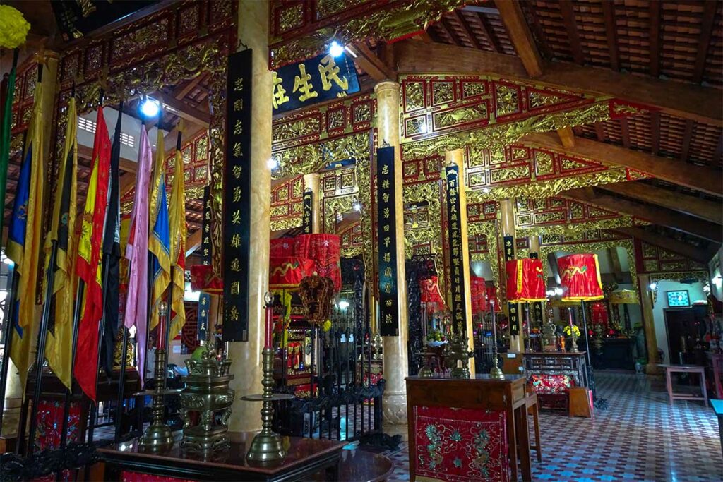 Interieur van de Nguyen Trung Truc tempel in Rach Gia met altaren en rode decoraties