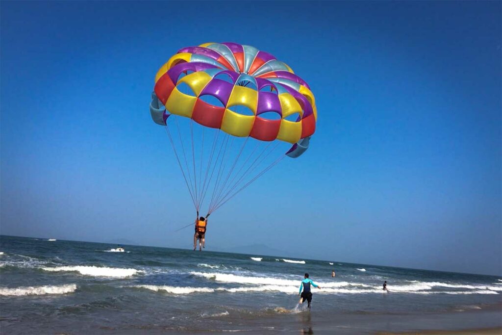 Parasailing boven zee bij An Bang Beach in Hoi An met strand en golven op de achtergrond