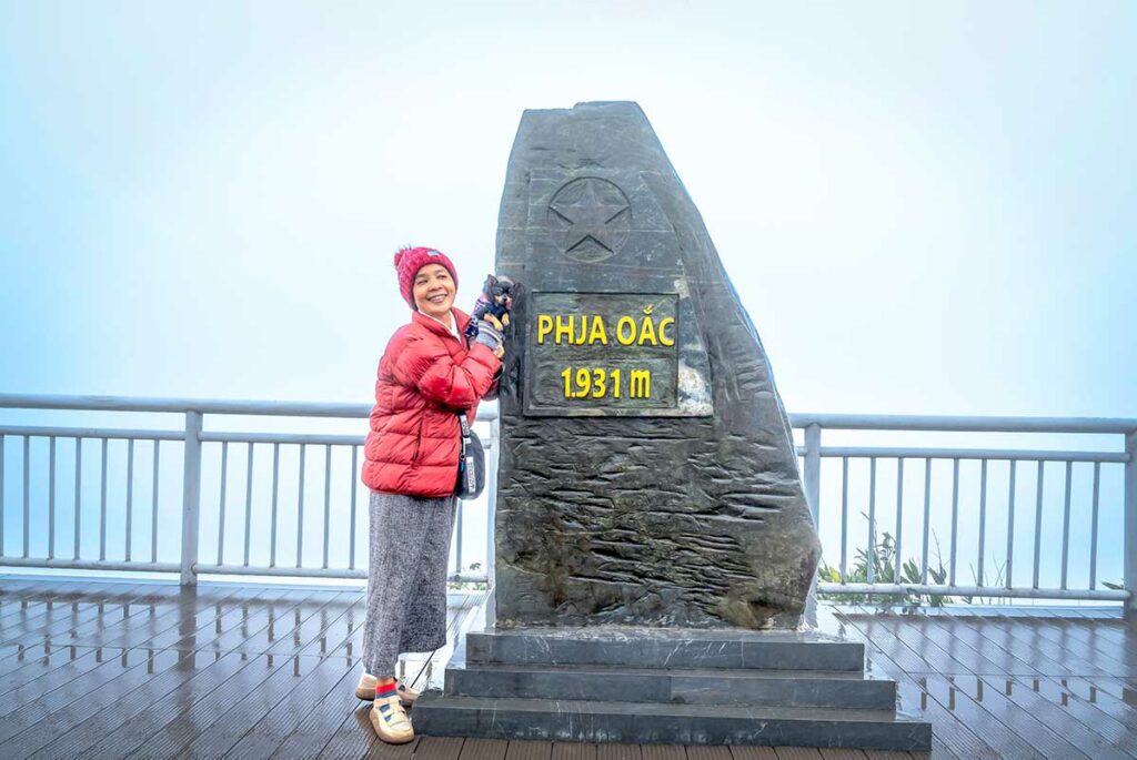 Top van Phia Oac Peak op 1931 meter hoogte met het stenen hoogtemonument en uitzicht over het mistige berglandschap van Cao Bang.