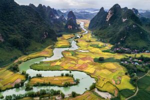 Luchtfoto van Phong Nam Valley met rivier, dorpen en uitgestrekte rijstvelden tussen kalkstenen bergen in Cao Bang