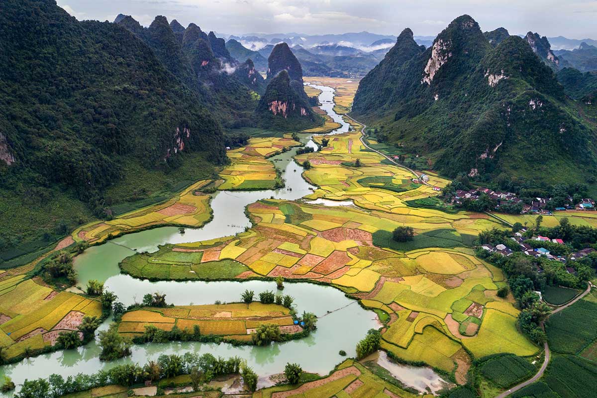 Luchtfoto van Phong Nam Valley met rivier, dorpen en uitgestrekte rijstvelden tussen kalkstenen bergen in Cao Bang