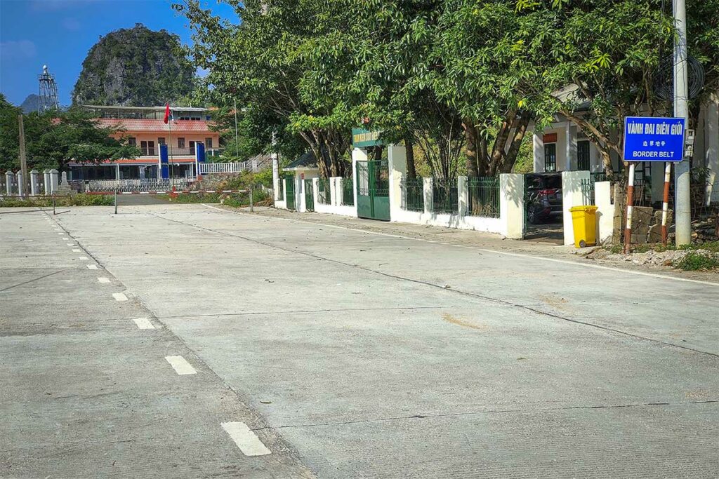 Grensovergang bij Ngoc Con in Phong Nam Valley, Cao Bang, met lege weg en bord dat de grenszone met China aangeeft