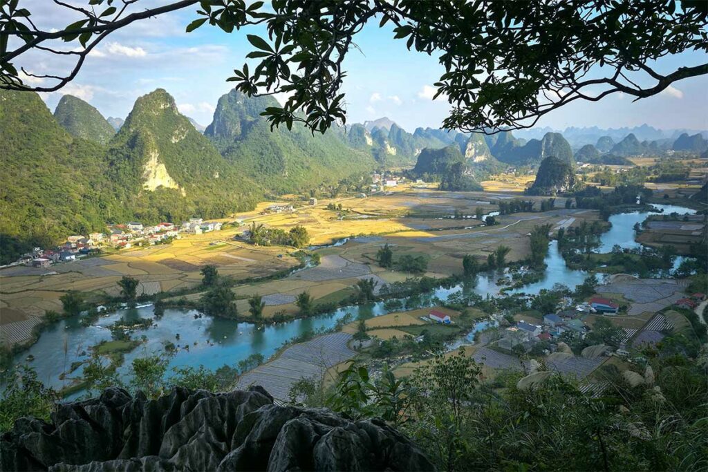 Uitzicht vanaf het Phong Nam Valley viewpoint over rivier, rijstvelden en karstbergen in Cao Bang tijdens helder weer