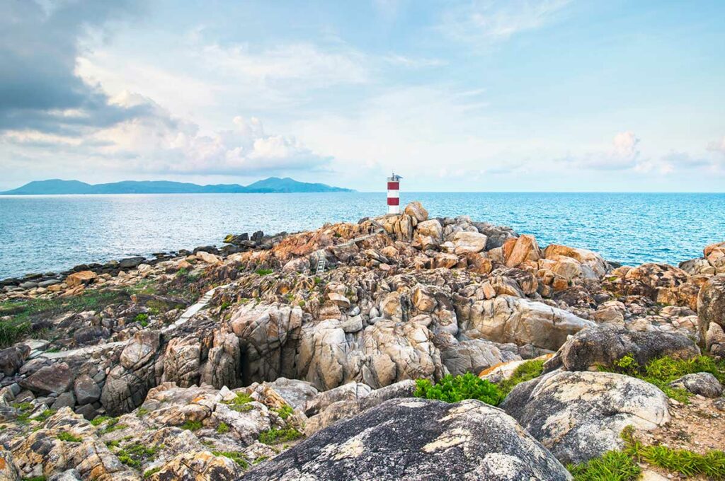 Vuurtoren op rotsachtige kustlijn in Phu Yen met uitzicht over zee, een sterke locatie voor kust- en landschapsfotografie in Vietnam.