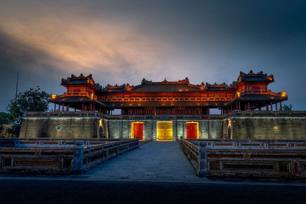 Verlichte poort van de Imperial City in Hue bij schemering, ideaal voor architectuur- en avondfotografie in Centraal-Vietnam.