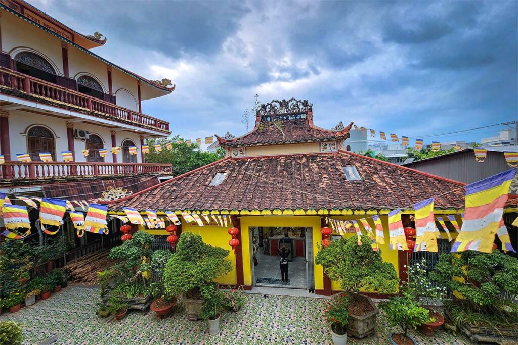 Quan Am Ancient Temple in Ca Mau met traditionele dakpannen en boeddhistische vlaggen