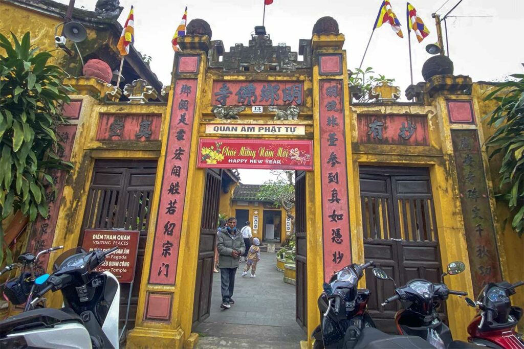 Ingang van Quan Am Pagoda in Hoi An met gele poort en traditionele Chinese inscripties