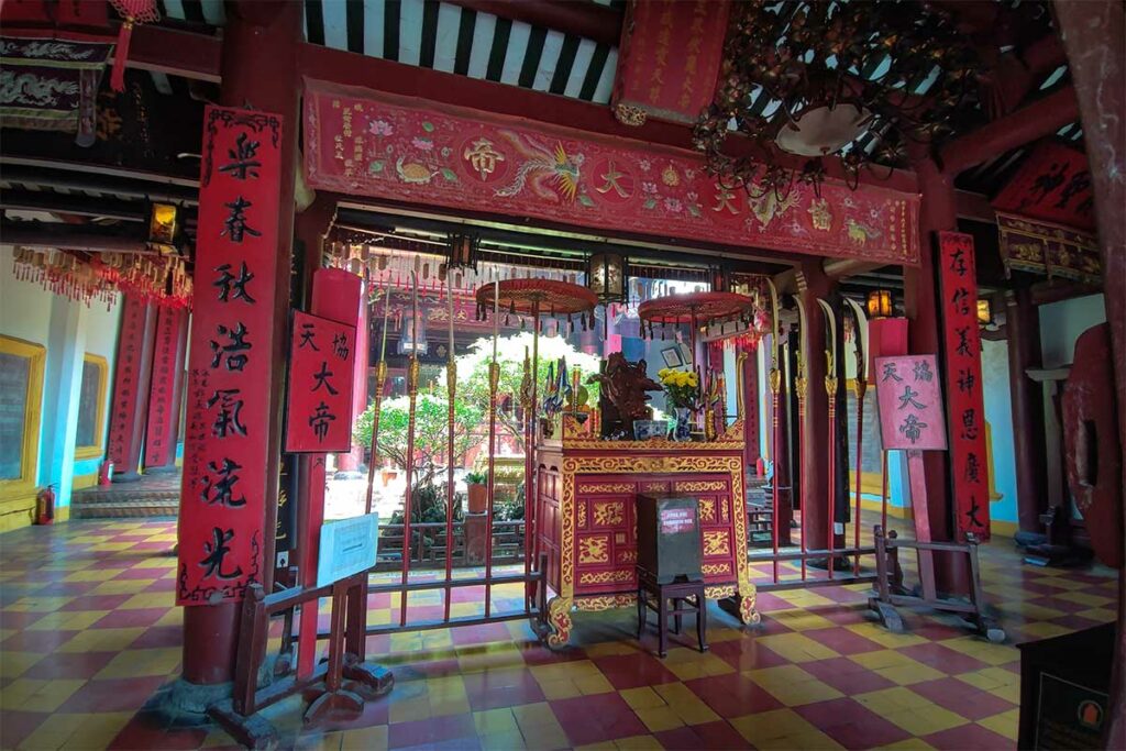 Interieur van Quan Cong Temple in Hoi An met rood altaar, Chinese kalligrafie en wierookspiralen