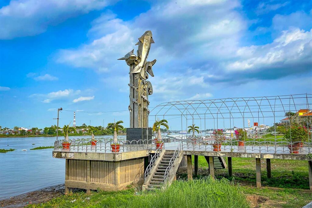 Basa meerval standbeeld aan de rivierpromenade van Chau Doc met uitzicht over de Hau rivier