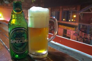 Fles Saigon Special bier met een volgeschonken glas op tafel in Vietnam, een populair lokaal lagerbier dat vaak ’s avonds wordt gedronken in cafés en bars