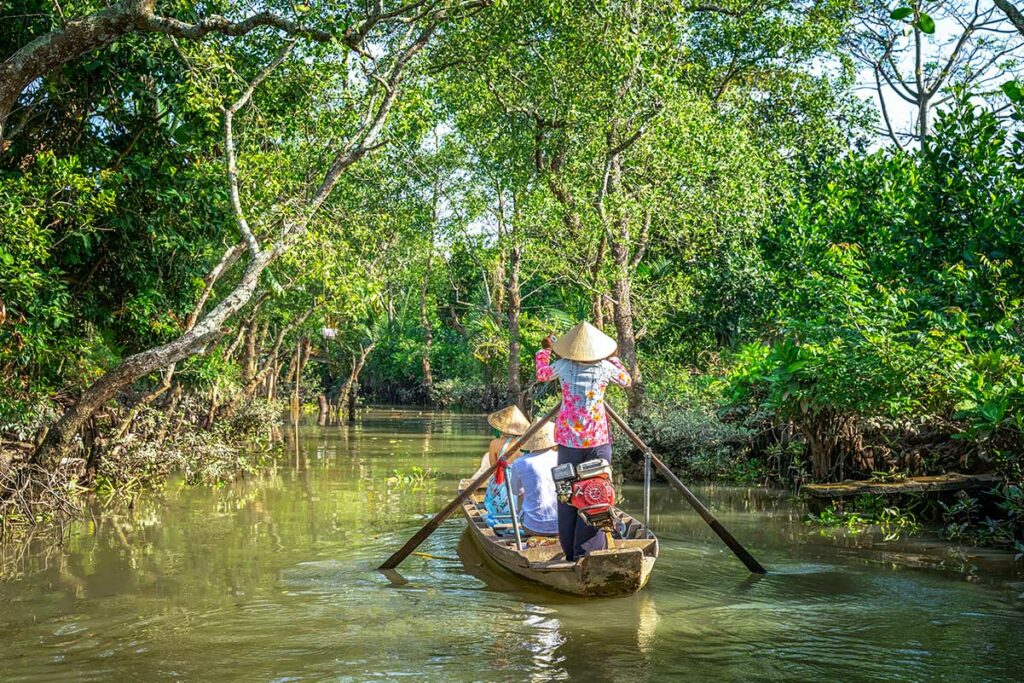 Sampan boottocht door smalle kanalen bij My Tho Mekong Delta omgeven door palmbomen en tropisch groen