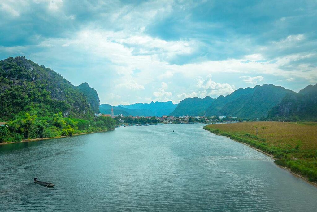 Uitzicht over de Son-rivier bij Phong Nha, met kalksteenbergen en groen landschap langs de oevers, onderdeel van de boottocht naar Phong Nha Cave.