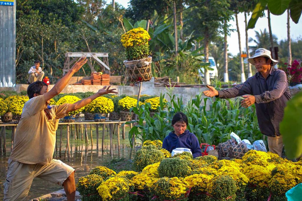 Boeren laden gele Tet bloemen op boten in Sa Dec Flower Village Mekong Delta