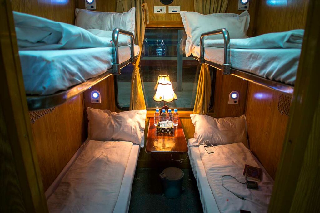 Vierpersoons slaapcoupé in de Vietnamese nachttrein met stapelbedden en kleine tafel in het midden