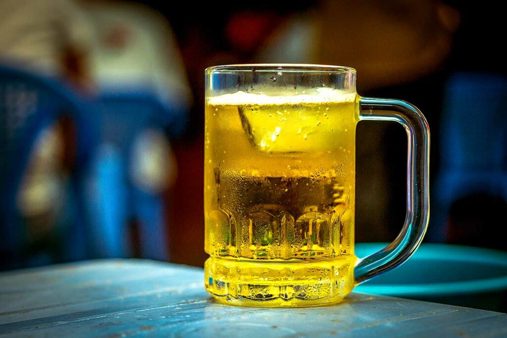 Glas bia hoi bier met ijs op een plastic tafel in Vietnam, licht ongepasteuriseerd tapbier dat populair is bij warm weer