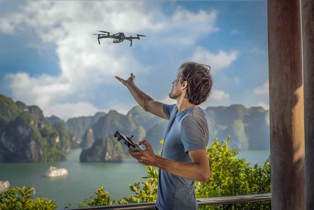Fotograaf vliegt een drone boven Halong Bay met uitzicht op kalkstenen eilanden, een populaire locatie voor dronefotografie in Vietnam.