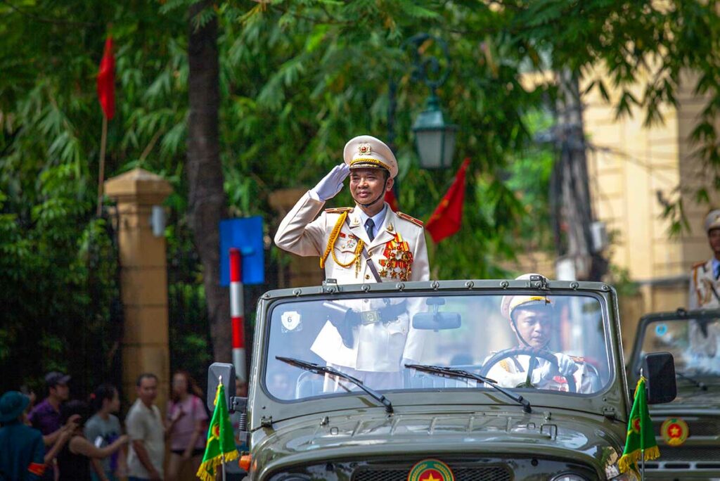 Officiële parade in Hanoi tijdens Vietnam National Day, met een hoge functionaris die het publiek groet tijdens de nationale ceremonie op Onafhankelijkheidsdag.