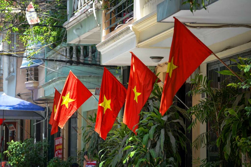 Vietnamese vlaggen met gele ster hangen langs een woonstraat tijdens Vietnam National Day, een typisch straatbeeld rond de Onafhankelijkheidsdag.