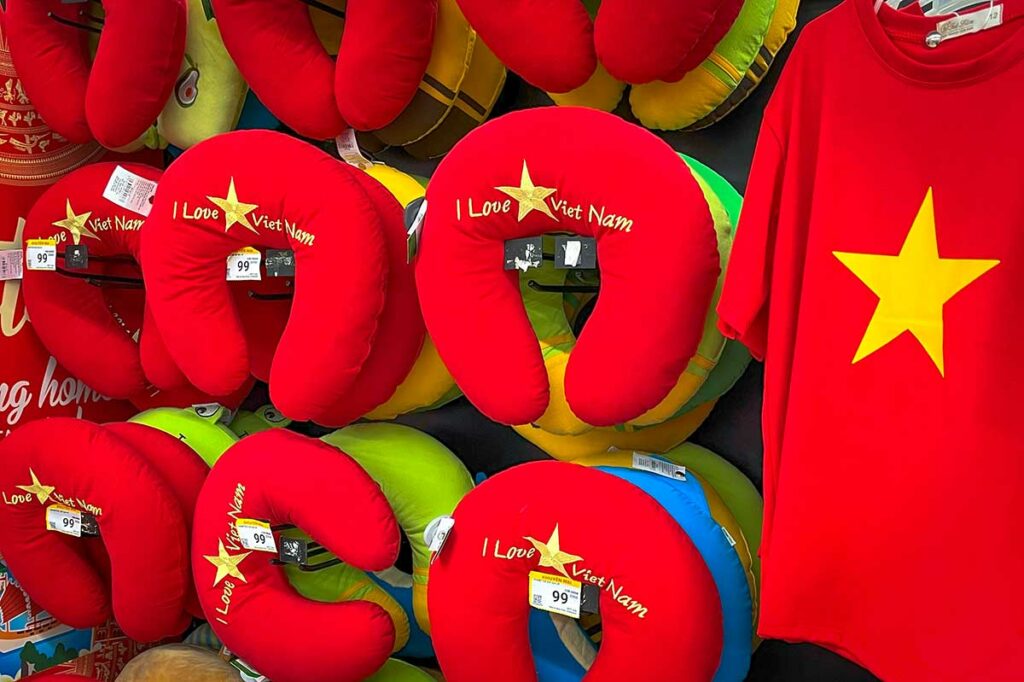 Souvenirwinkel met rode T-shirts en nekkussens met de gele ster van de Vietnamese vlag en de tekst “I Love Vietnam”, typisch straatbeeld in toeristische gebieden.