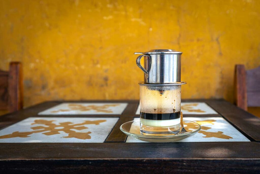 Vietnamese koffie geserveerd met een phin-filter, een koffietraditie die zijn oorsprong vindt in de Franse koloniale invloed in Vietnam.