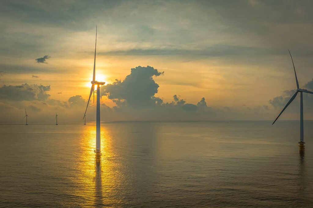 Windturbines bij Ba Dong Beach in Tra Vinh tijdens zonsondergang boven de Zuid-Chinese Zee
