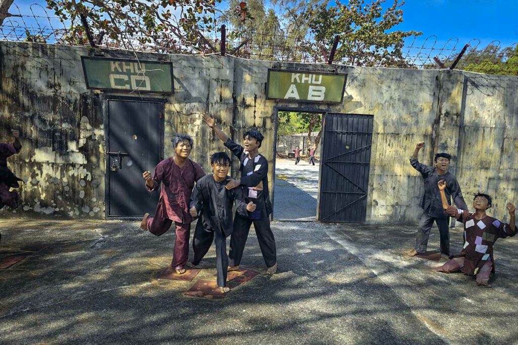 Standbeelden van gevangenen in de American Tiger Cages van Phu Binh Prison op Con Dao die de leefomstandigheden tijdens detentie uitbeelden