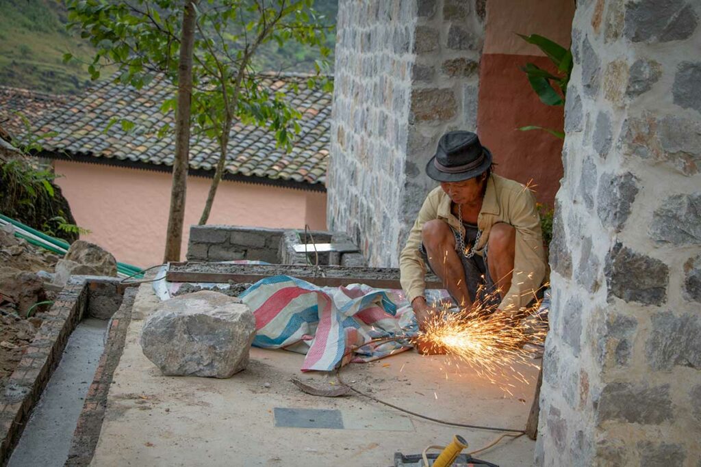 Lokale vakman werkt aan metalen constructie tijdens de bouw van Ha Giang Aya Lodge van Local Vietnam, een kleinschalige berglodge in Ha Giang