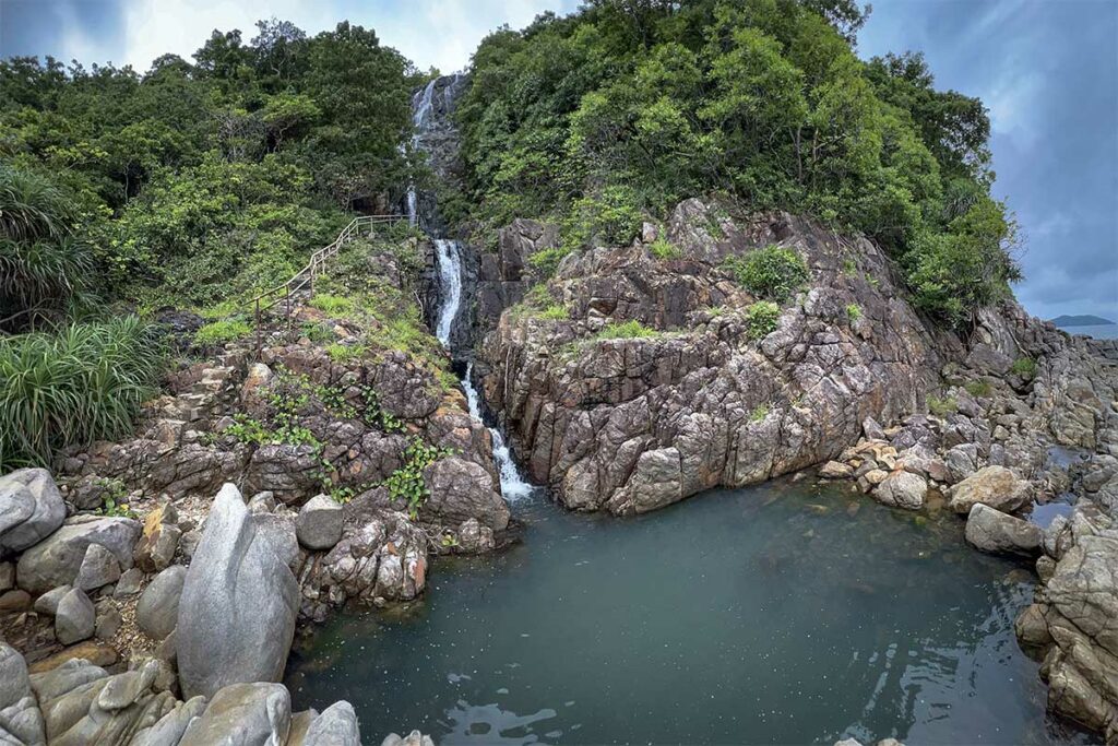 Waterval langs de trekkingroute naar Bai Bang in Con Dao National Park met natuurlijke poel tussen rotsen en jungle