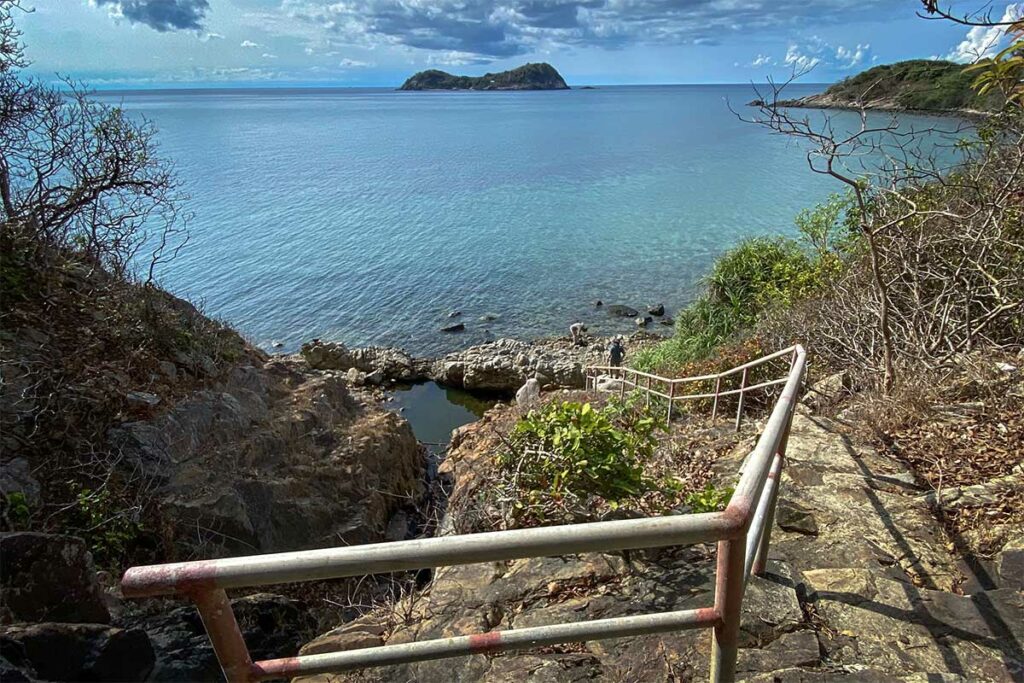 Uitzicht vanaf het pad naar Bai Bang Beach in Con Dao National Park met trappen, rotsen en zee op de achtergrond