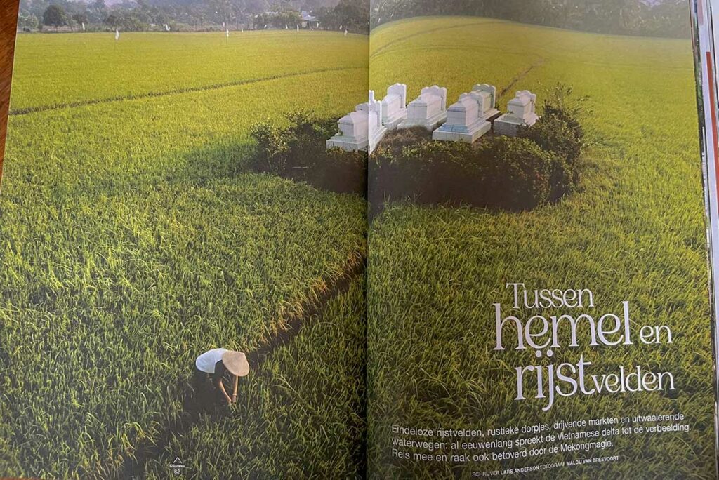 Spread in Columbus Travel magazine met uitgestrekte rijstvelden in An Giang in de Mekong Delta, met boer in het veld en een kleine begraafplaats midden in het landschap.