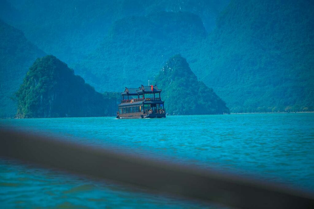 Boot op Tam Chuc Lake omringd door mistige karstbergen bij Tam Chuc Pagoda