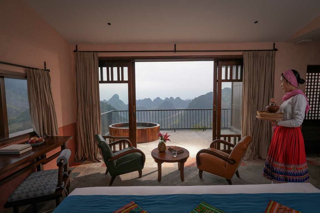 Bungalow met balkon en houten bad bij Ha Giang Aya Lodge by Local Vietnam met panoramisch uitzicht over bergen