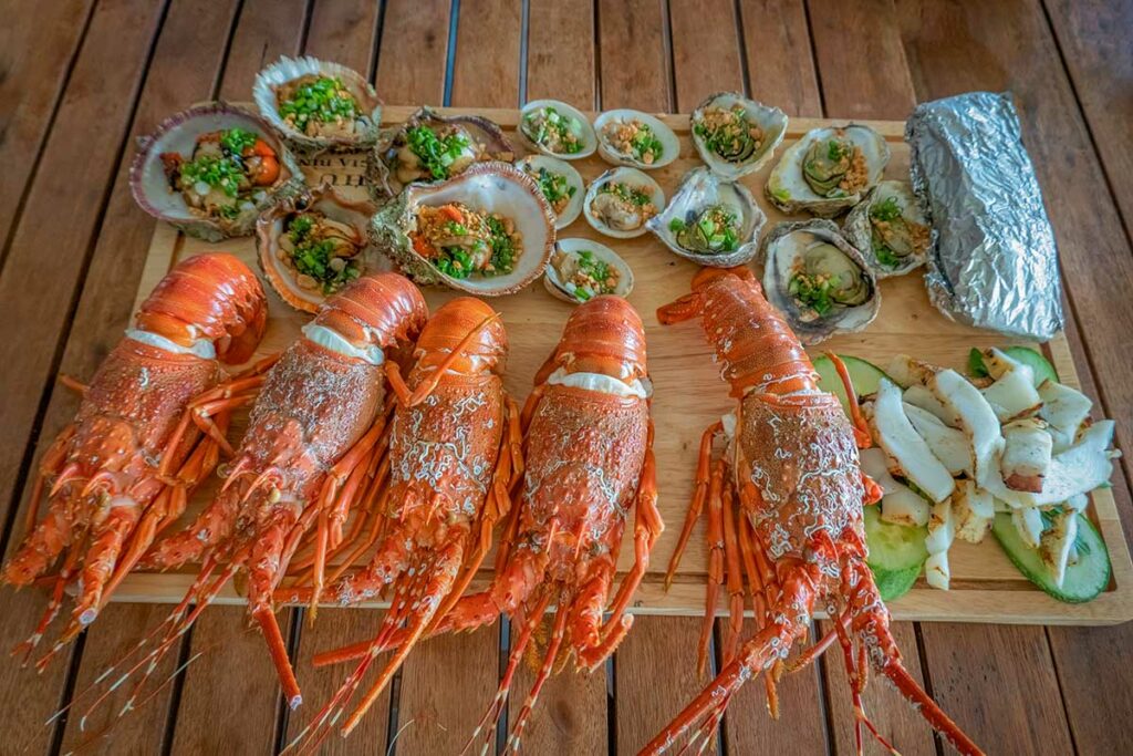Verse zeevruchten in Cam Ranh met kreeft, schelpdieren en gegrilde vis geserveerd op tafel.