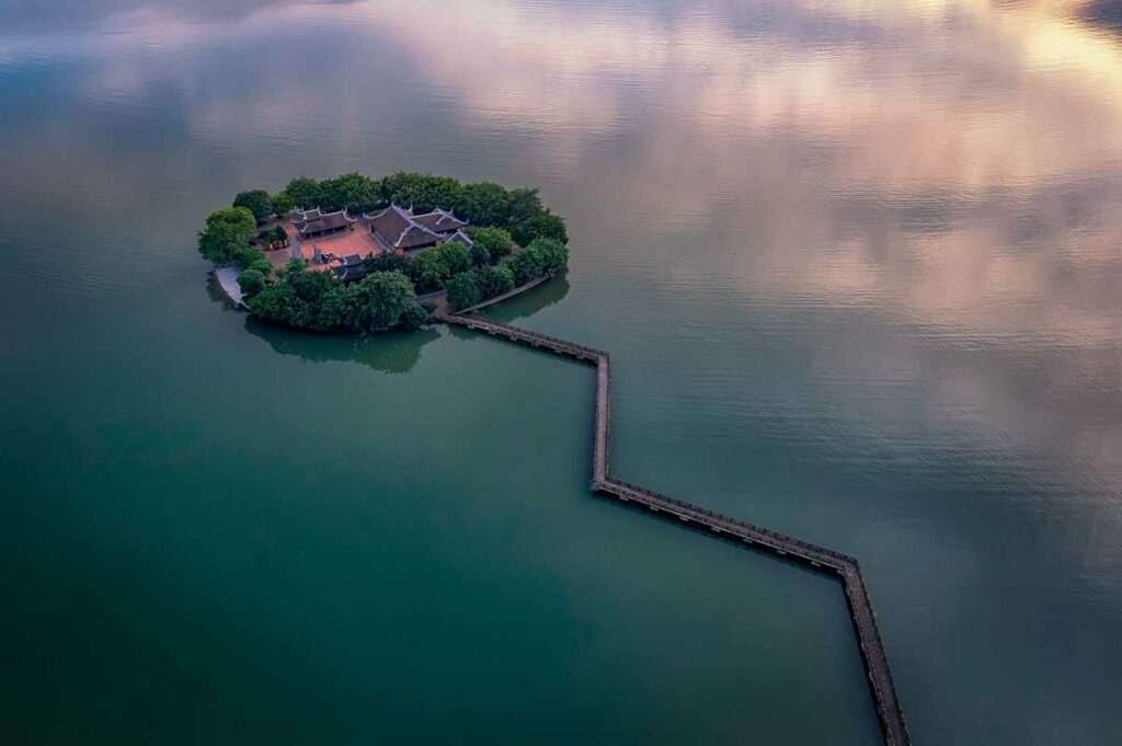 Klein eiland met tempel in Tam Chuc meer verbonden via een lange brug