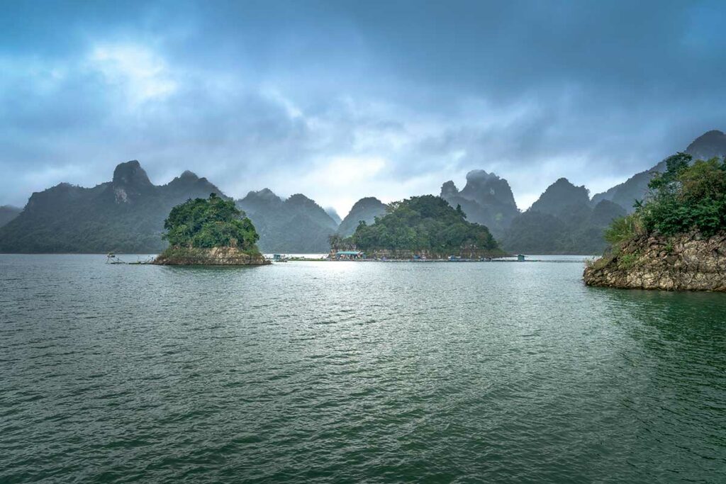 Kleine groene eilandjes in Hoa Binh Lake Vietnam met mistige bergen en kalm water