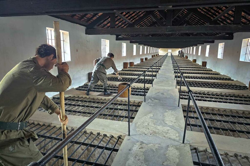 Binnenruimte van de French Tiger Cages op Con Dao met smalle cellen en bewakersgang boven de gevangenen, symbool van zware detentieomstandigheden